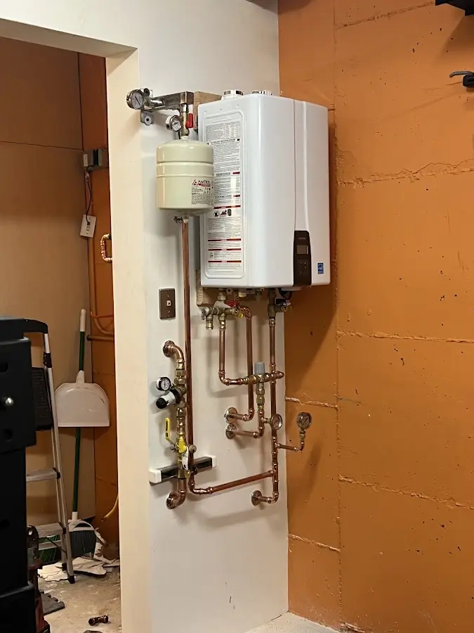 Plumbing technician inspecting water heater connections in Anderson